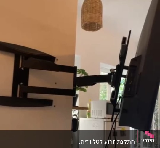 זרוע טלוויזיה מותקנת על קיר עם כבלים תלויים
